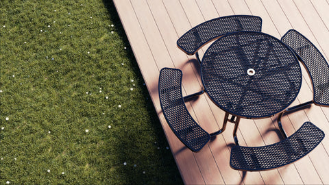 Black metal outdoor furniture set on a wooden deck with grass in the background
