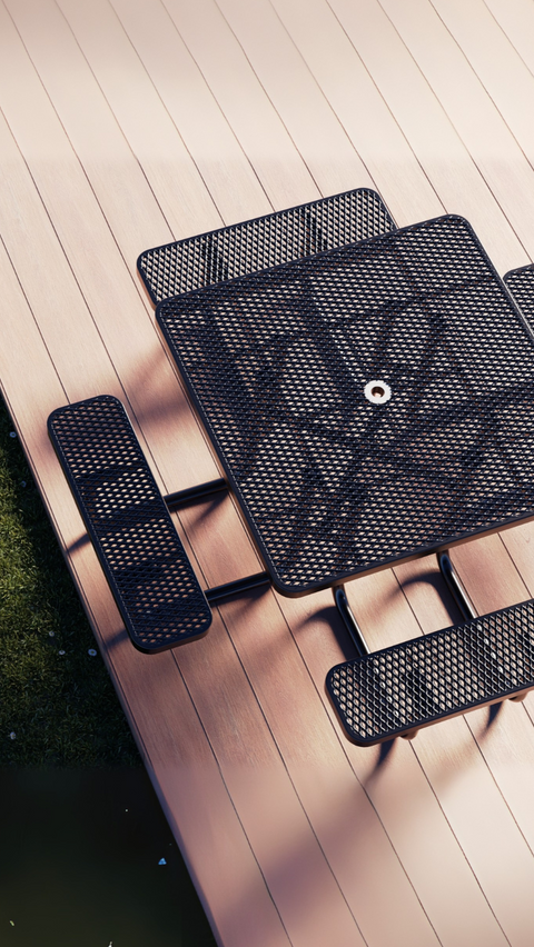 Black metal picnic table set on a wooden deck next to grass